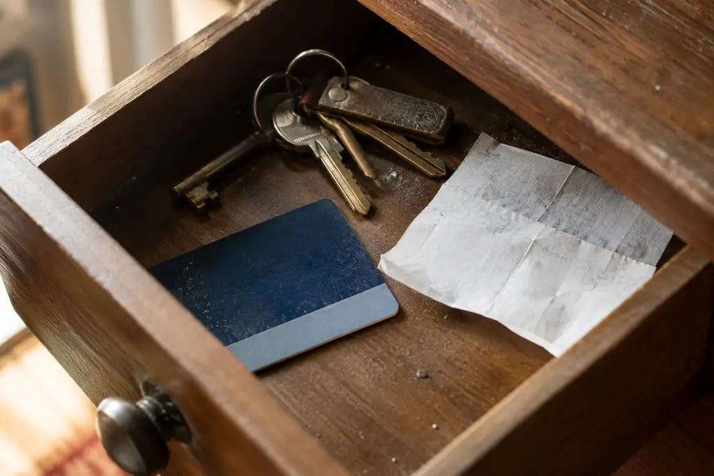 Une carte de magasin anonyme dort dans un tiroir avec des clés et un ticket retourné.